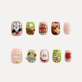 Christmas Sonata 3D square short press-on nails with holiday 3D designs: chef Snoopy, green wreath (bow), reversed "Merry Christmas" text, red gingerbread stars, snowy pink, beaded wreath, Santa, candy cane, red apple. Festive nail art for Christmas.