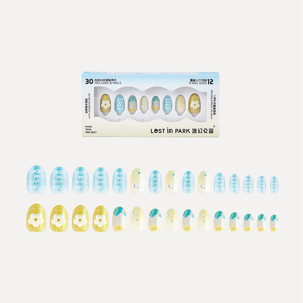 3D press-on nails from Lost in Park's Blossom Mirror collection. Box includes 30 nails in 12 sizes. Nails feature pastel blue, yellow, and cream colors with floral designs, text ("SIDE ONE THAN MORE"), and gradient accents.