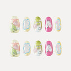 3D press-on nails (Bubblegum Heart collection) with two rows of five medium round nails. Pastel colors (yellow, green, pink) with 3D details: birds, flowers, abstract shapes, glitter, pearls, and text (e.g., "507"). Whimsical, playful designs.
