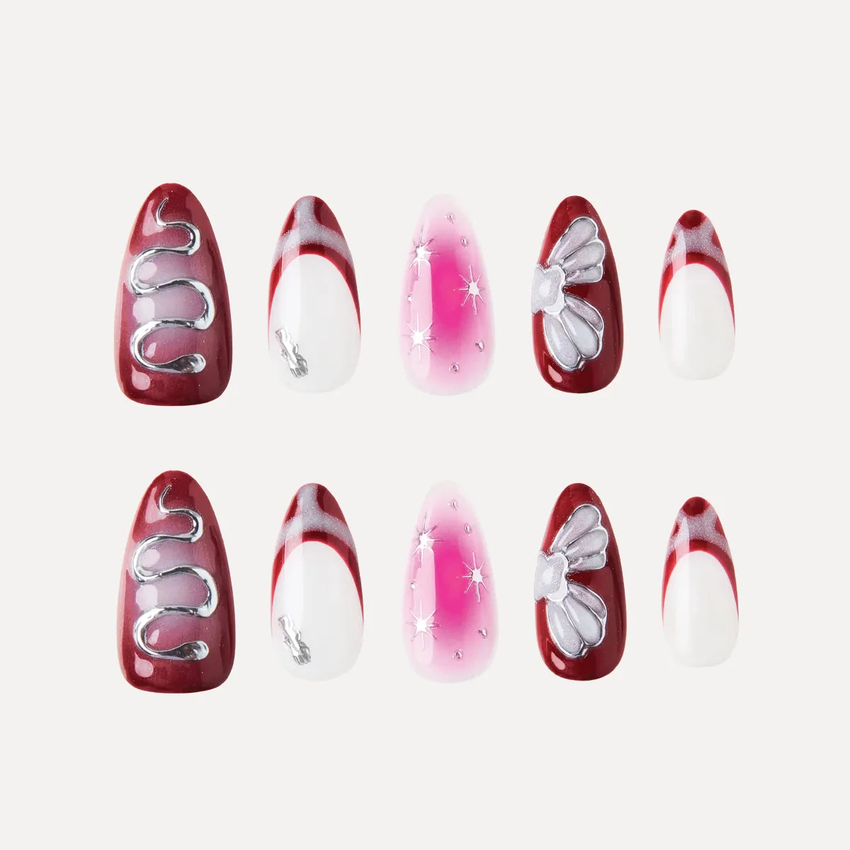 Set of almond-shaped false nails from the Park Select "Cherry Stardust" collection, featuring a cherry red and white color scheme with silver accents. Designs include deep cherry red bases with silver wavy lines or bows, white bases with cherry red curved tip stripes, and a pink gradient base with silver stars/dots. The medium-length nails (two of each design) create a festive, elegant manicure look.