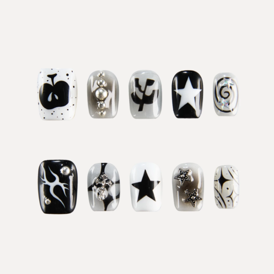 Flat lay of LOST in PARK Astro Courier short square press-on nails in black, white, and silver with star motifs, flames, graphic symbols, and 3D metallic studs.