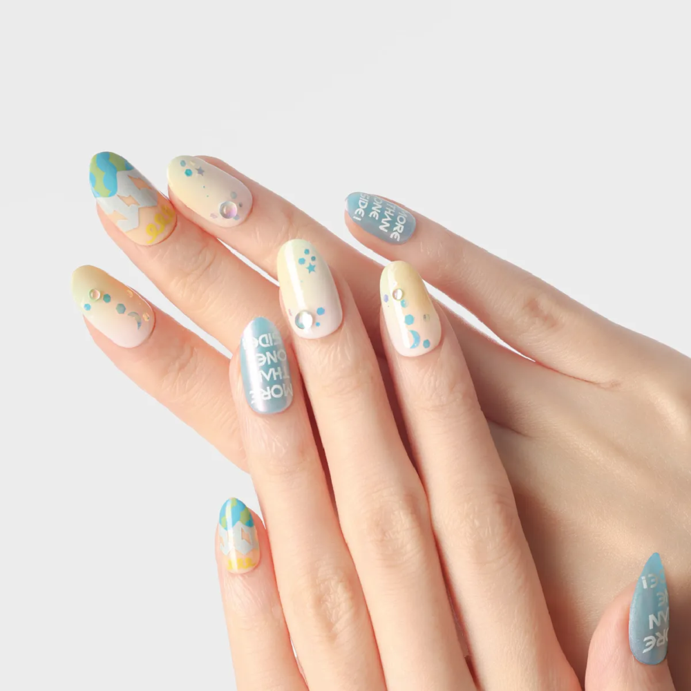 Pastel gradient press-on nails with moon, stars, and abstract patterns displayed on both hands.