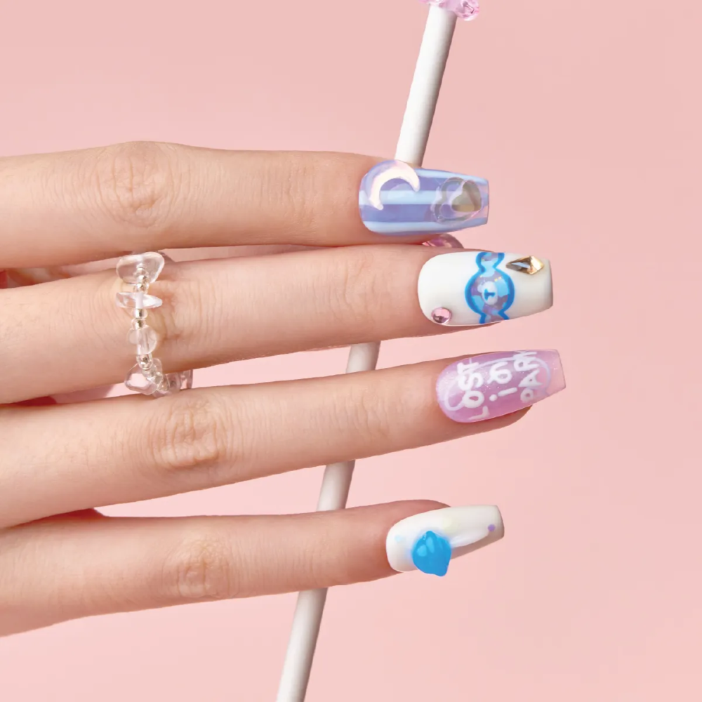 Blue Lollipop press-on nail set worn on hand, featuring blue jelly candy patterns, white base accents, and pastel purple lettering.