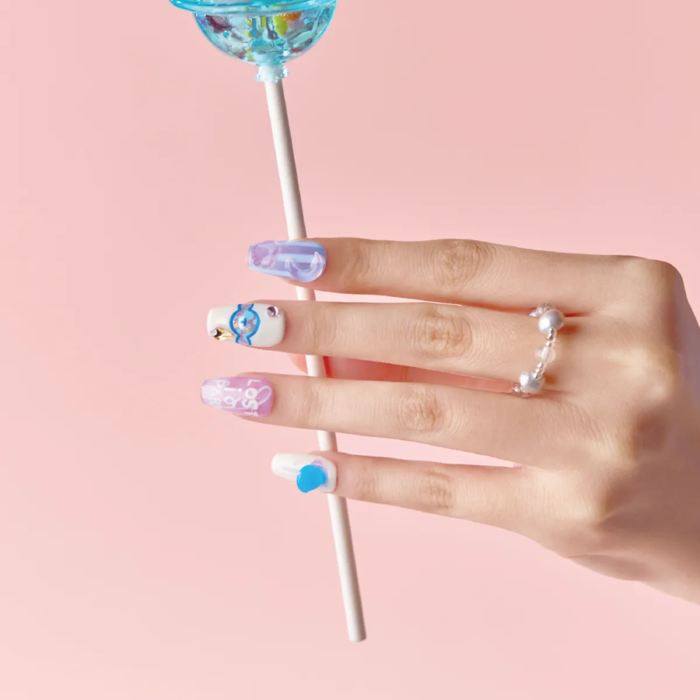 Hand showcasing Blue Lollipop press-on nails while holding a large blue candy-shaped lollipop