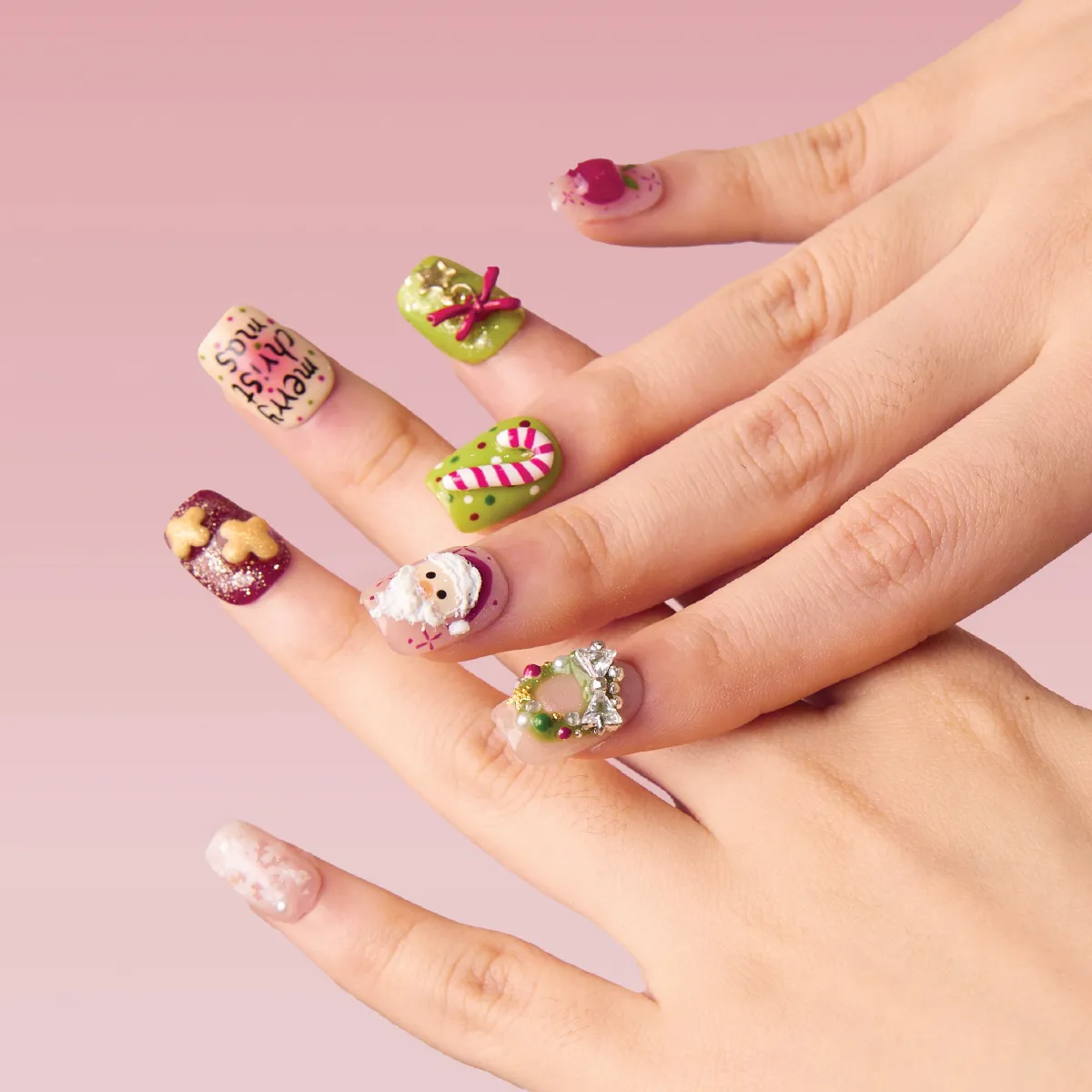 Hands showing festive short square Christmas nails with Santa Claus, candy cane, wreath, and holiday bow accents.