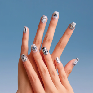 Hand wearing LOST in PARK Chrome Vision short square press-on nails with silver chrome 3D embellishments and graphic designs against a blue background.