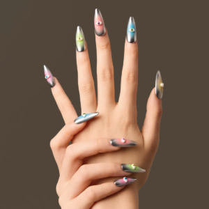 Front-facing hand pose showcasing “Cosmic Vigil” nails with metallic silver finishes and vibrant colored eye embellishments on each fingertip.