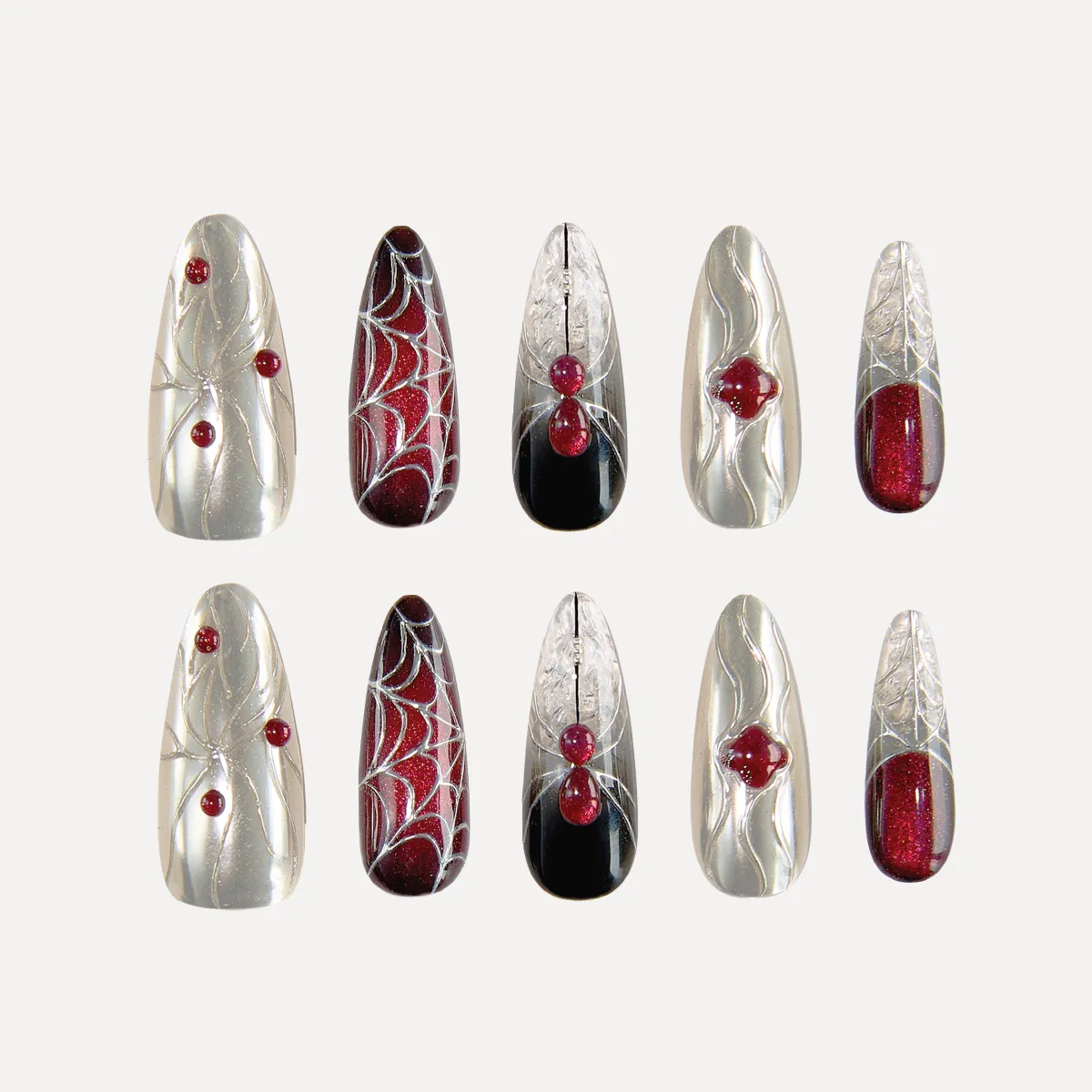 Flat-lay display of the “Crimson Whisper” long oval press-on nail set featuring silver chrome textures, red gem accents, and black-red gradient spiderweb designs.