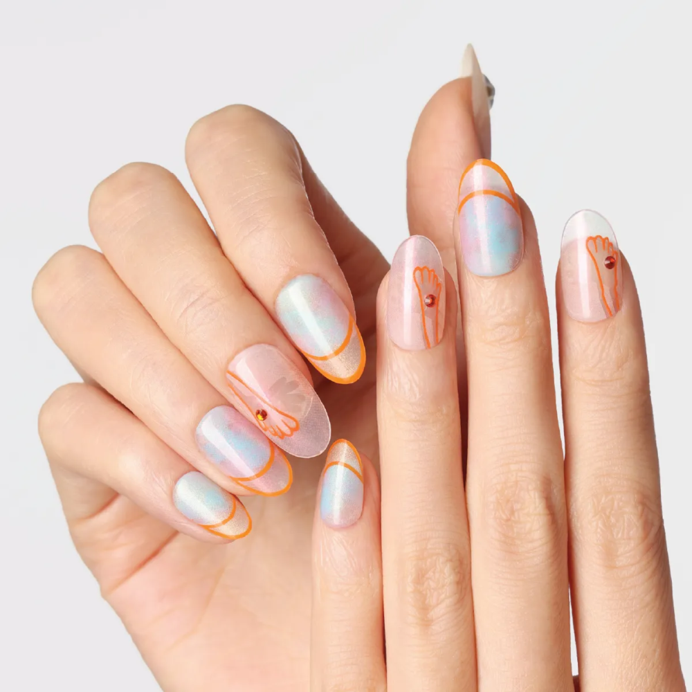 Hand pose displaying the full “Crystal Mist” nail set with soft holographic sheen, orange graphic outlines, and translucent pastel finishes.