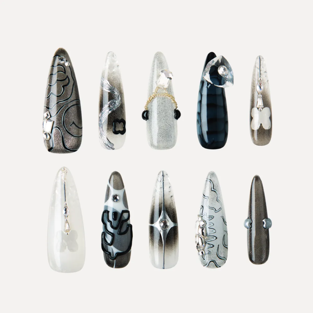 product_lost-in-park-Cyber-Pulse-press-on-nails Flat lay of Cyber Pulse long stiletto press-on nails arranged in rows with metallic gradients, chrome 3D pieces, and futuristic black-silver designs