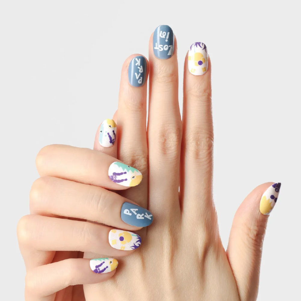 Day Dreaming press-on nails arranged on both hands with abstract flowers, character silhouettes, and blue text accents