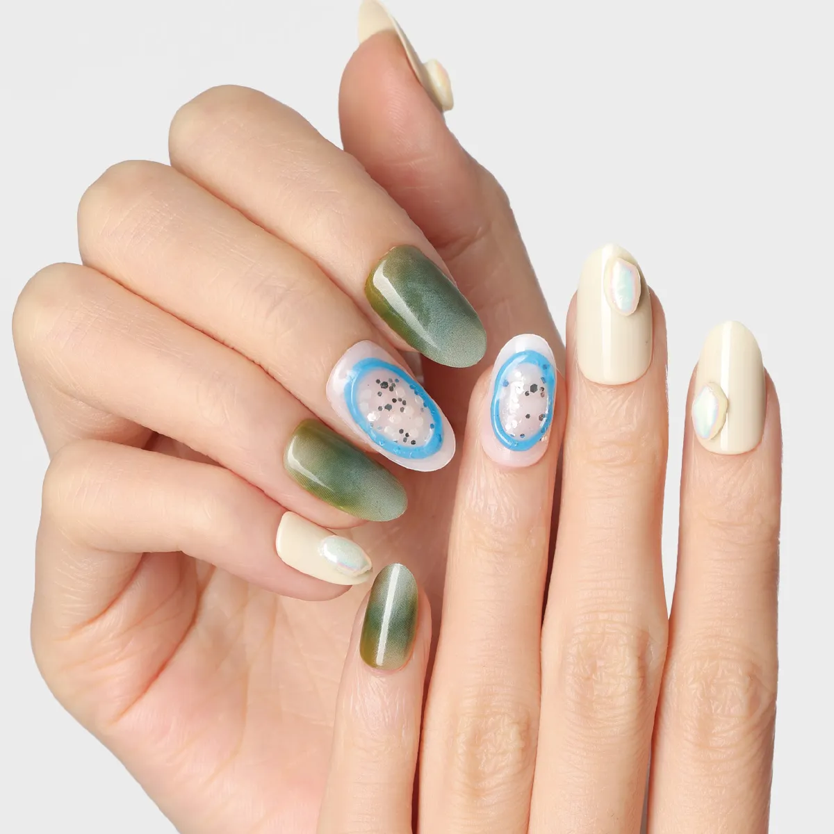 Emerald Lake press-on nail look with soft green gradient, nude pearl accents, and oval jelly centerpiece