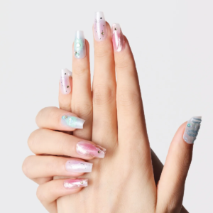 Hand showing pastel galaxy-inspired press-on nails with shimmer and 3D pearl details