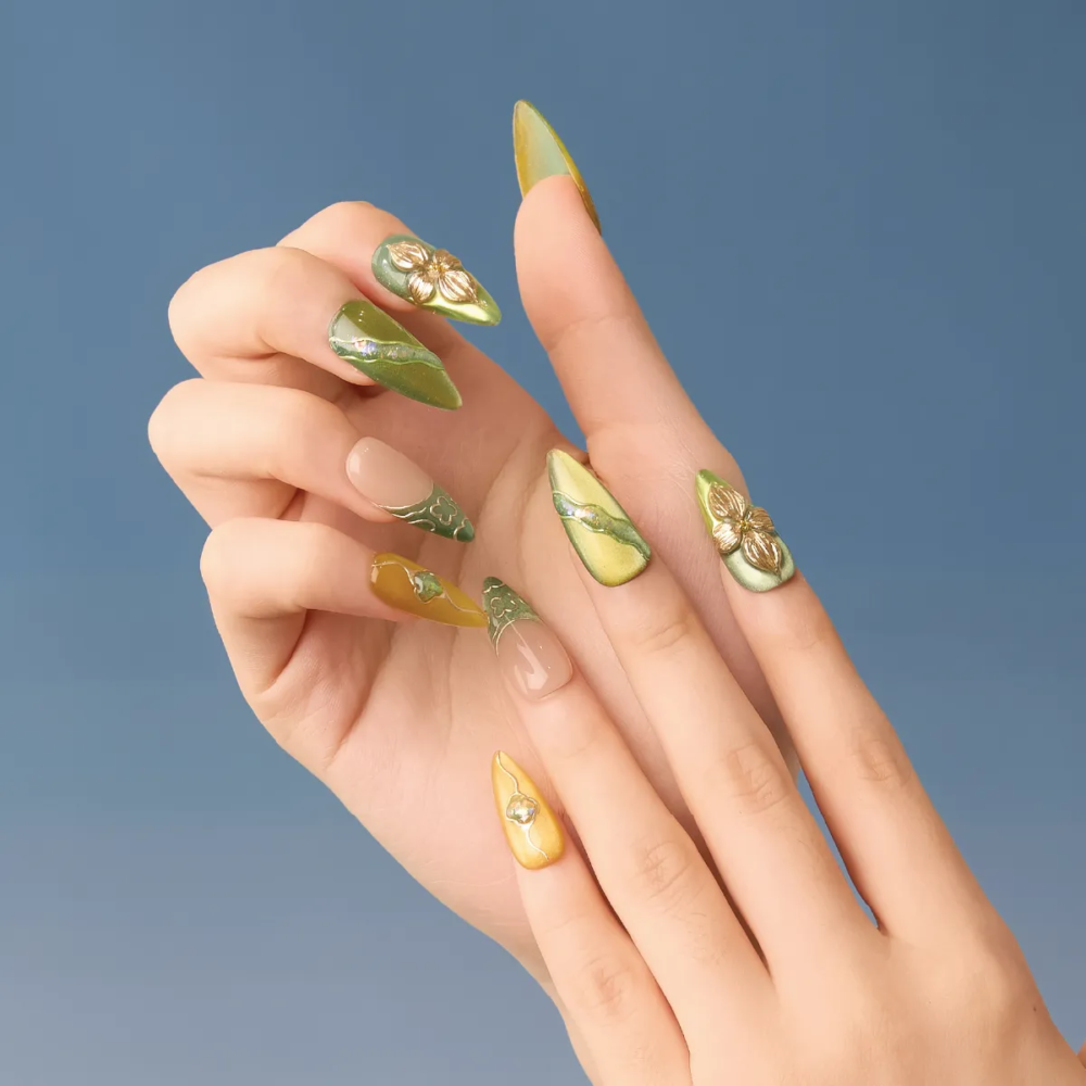 Hand model wearing LOST in PARK's Jade Gleam press-on nails with green and yellow floral 3D design