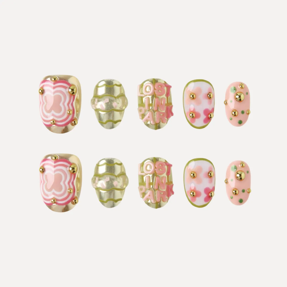 Ten-piece press-on nail set featuring playful pink, gold, and green designs with 3D lettering and patterns