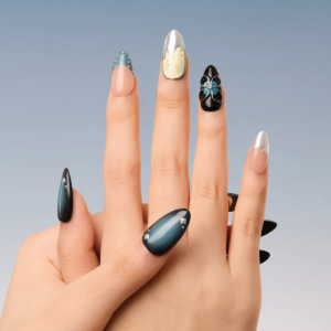 Hand model showcasing Midnight Reverie press-on nails with silver, gold, blue, and floral embellishments.