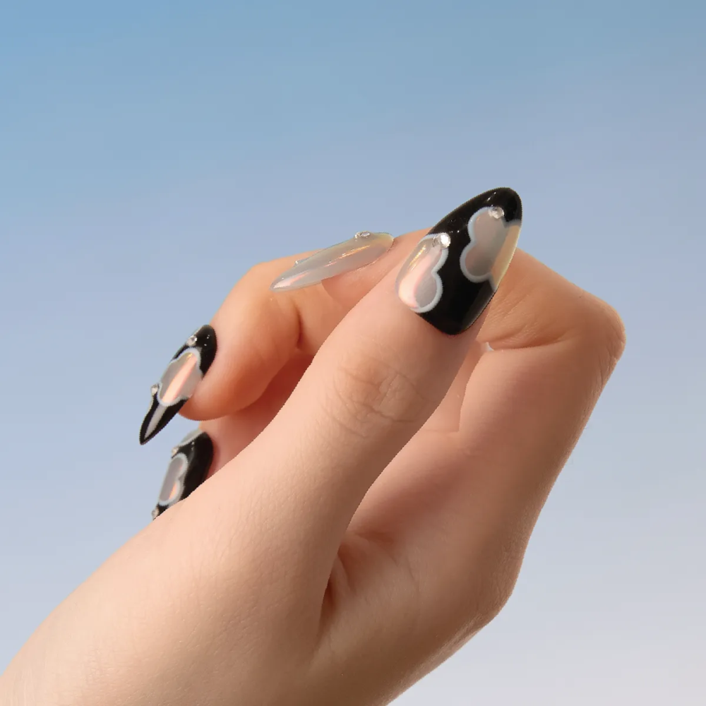 Close-up of LOST in PARK Phantom Bloom nails featuring black base and reflective pink flowers