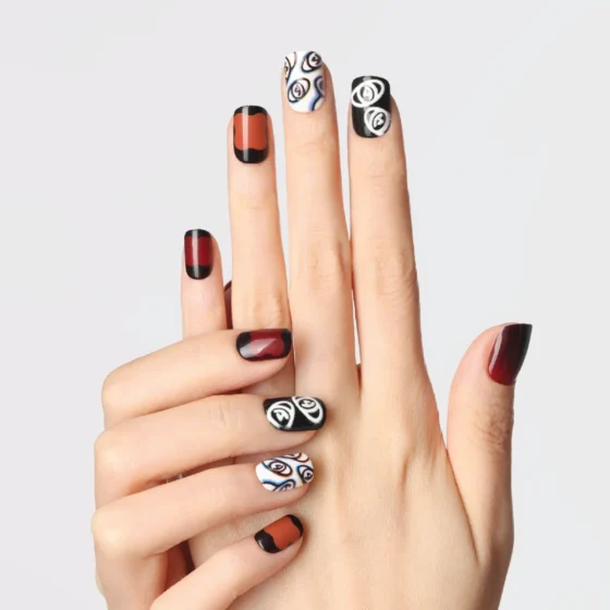 plum rhapsody press-on nails in deep red and black tones with abstract white eye illustrations and gradient effects on fingers.