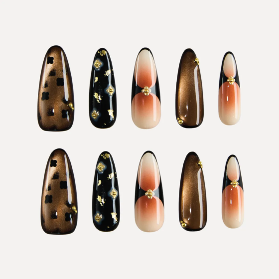 Top view of long almond press-on nails set featuring ten unique nail designs in brown, black, nude, and gold.