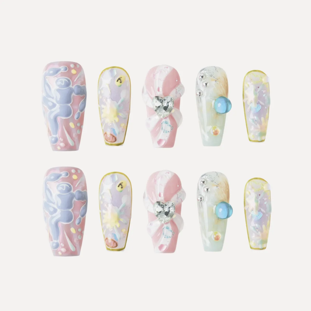 Full Sweet Dream Bomb nail set (10 pieces) laid flat showing pastel designs, 3D hearts, and gem embellishments.