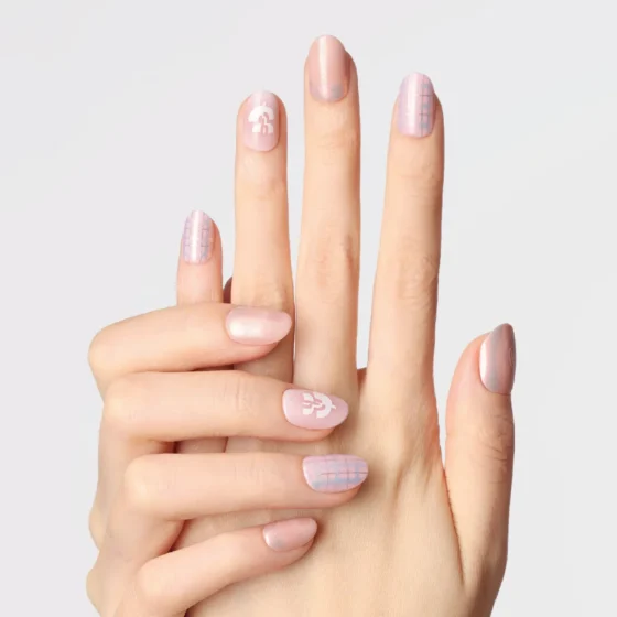 Close-up of hands wearing LOST in PARK's pink plaid press-on nails with white logo detail.