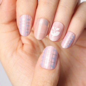 Macro view of pastel pink plaid press-on nails featuring glossy shimmer and minimalist floral logo.