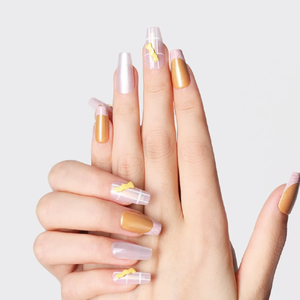 Long coffin press-on nails featuring gold metallic polish and translucent pink grid accents with yellow candy charms.