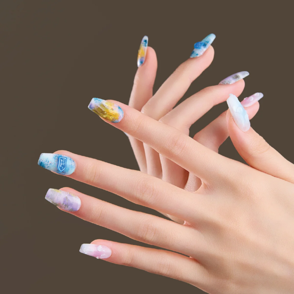 Medium coffin press-on nails worn on hand with abstract watercolor design in blue, yellow, and pastel tones