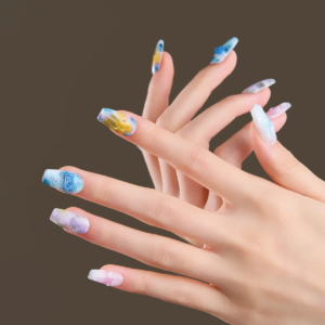 Medium coffin press-on nails worn on hand with abstract watercolor design in blue, yellow, and pastel tones