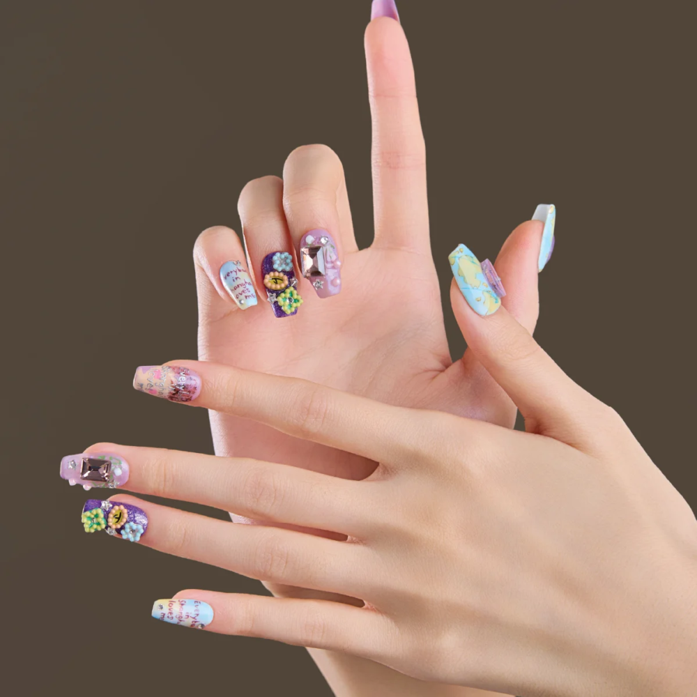 Hand model wearing LOST in PARK medium coffin press-on nails with colorful artistic designs