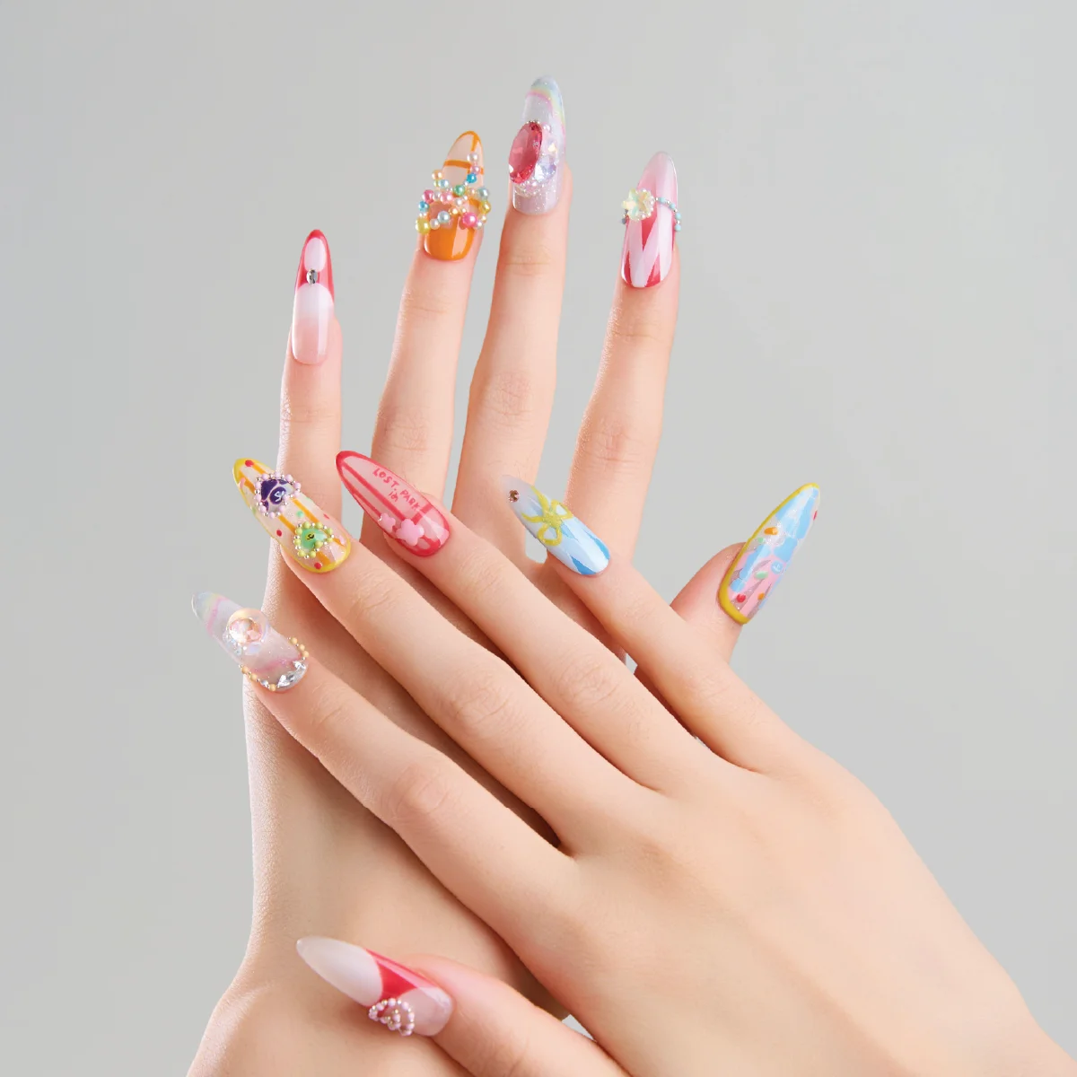 Rainbow Darling long oval press on nails worn on hands with colorful candy tones and 3D embellishments