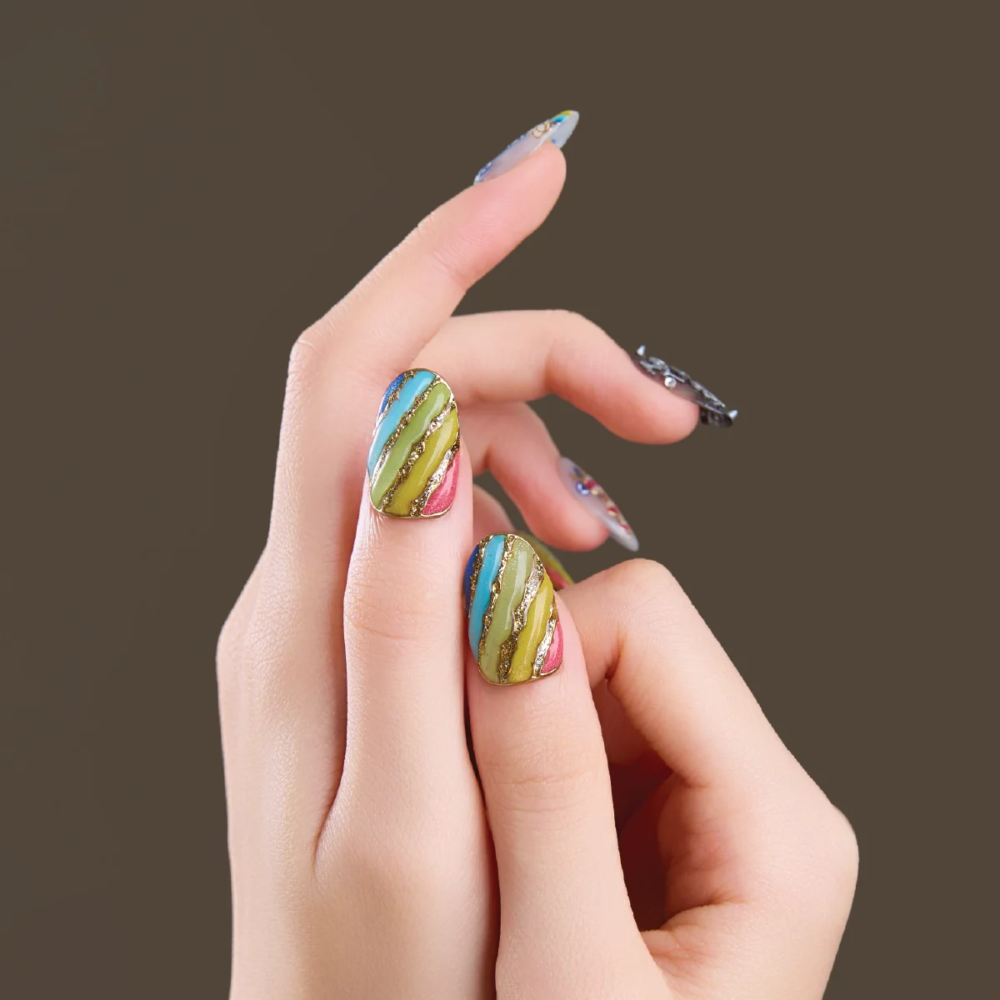 Close-up of short oval press-on nails with rainbow and graphic details