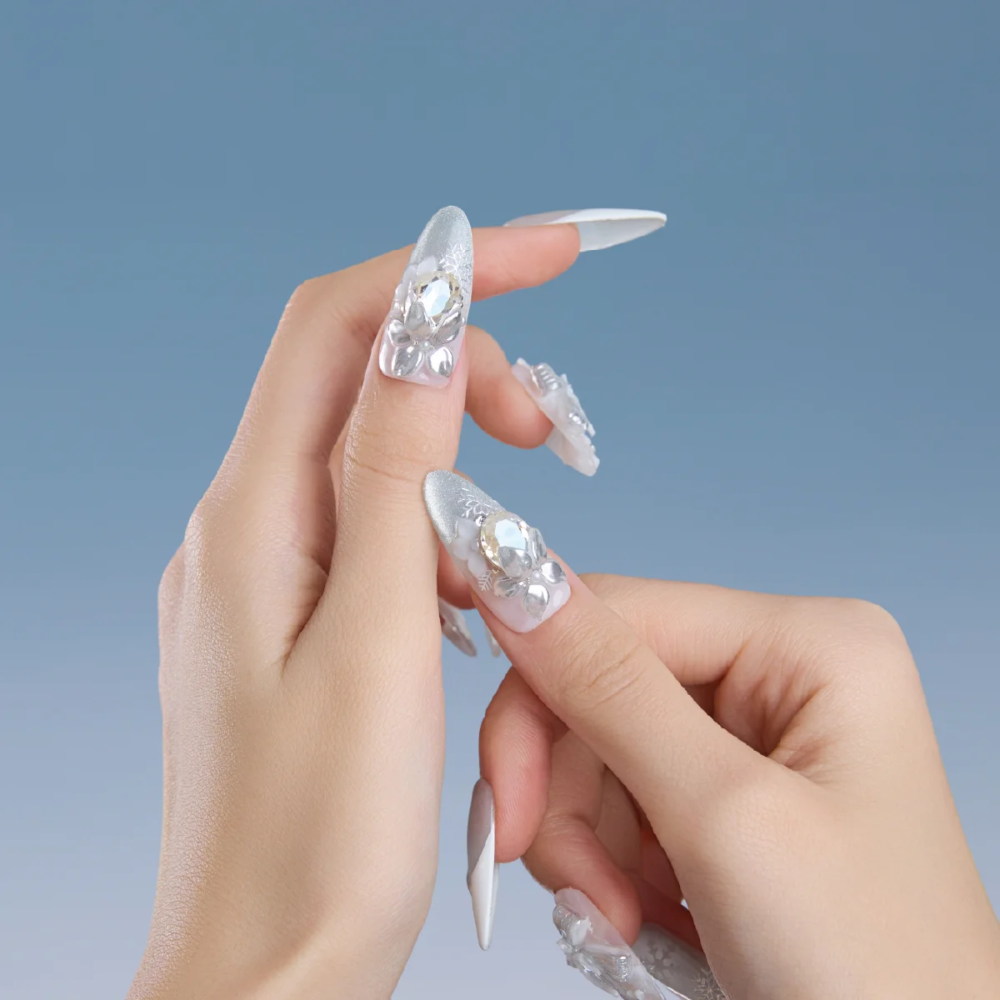 Long almond press on nails featuring silver chrome, snowflake pattern and crystal embellishments