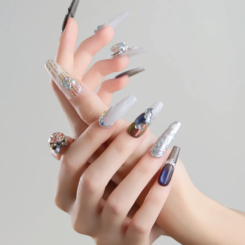 Detailed view of long coffin press on nails with metallic gradients sculpted designs and rhinestones