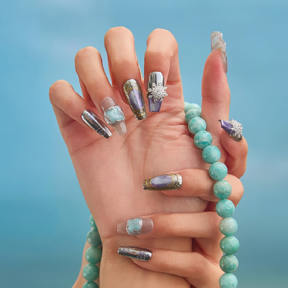 Close-up of crystal and metallic press-on nail design