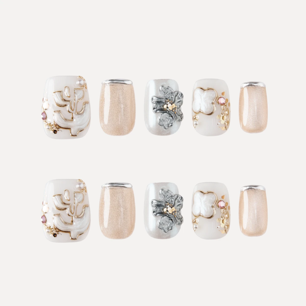 Serene Pearl press-on nail set flat lay with floral, pearl, and nude shimmer designs