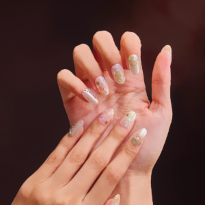 Short oval floral press on nails worn on hands with soft pastel details