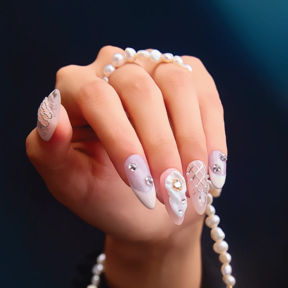 Medium almond press-on nails with pearl details and sculpted silver design close-up