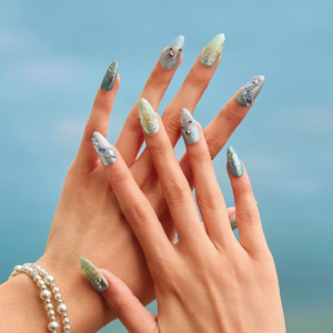 Medium almond press on nails worn on hands with silver green metallic finish and sculpted details